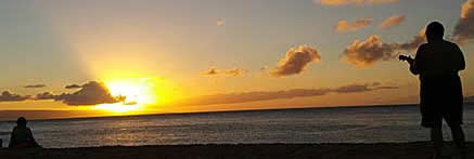 Ukelele player on the beach at sunset