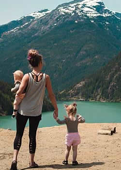 Woman with 2 children at mountain lake